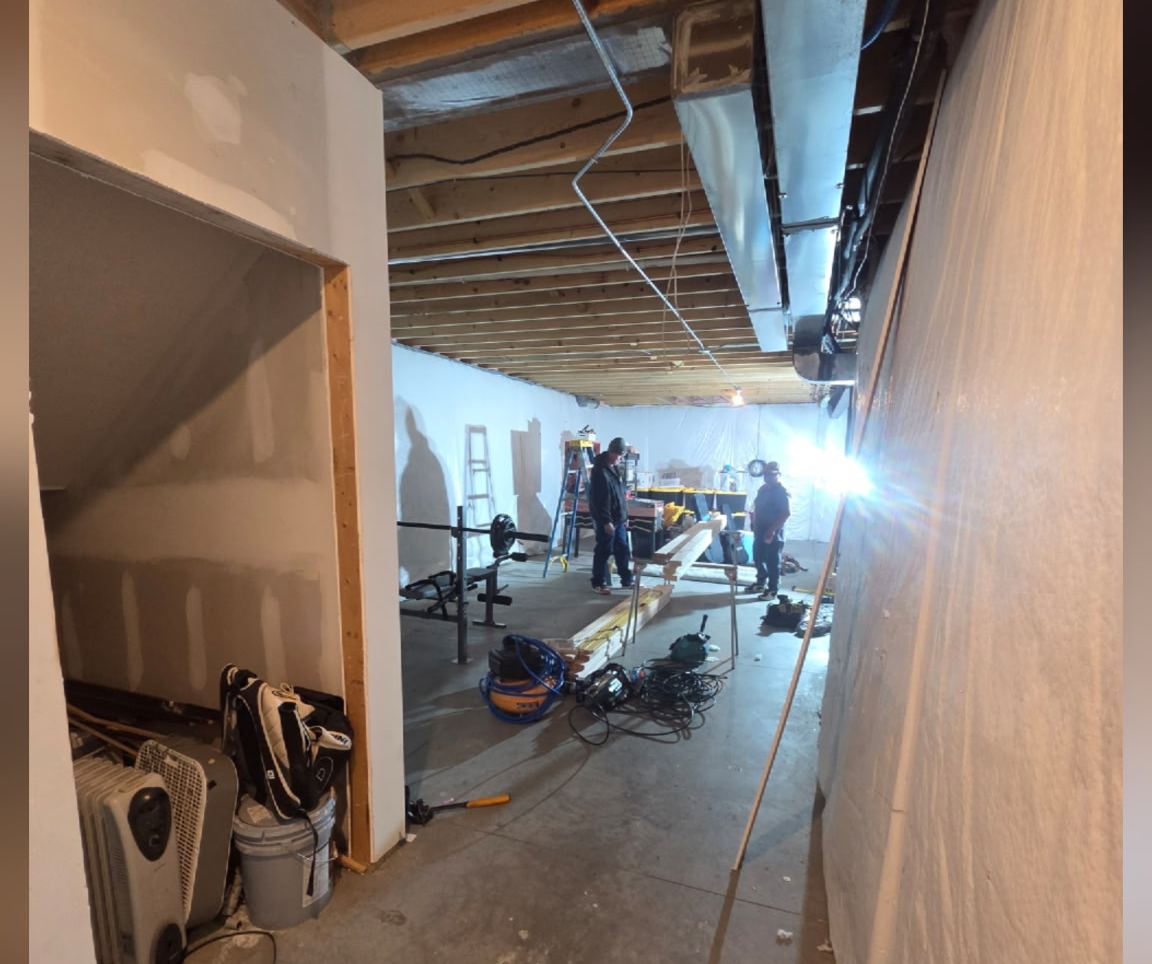Unfinished Omaha basement with exposed joists and bare concrete floor before remodeling