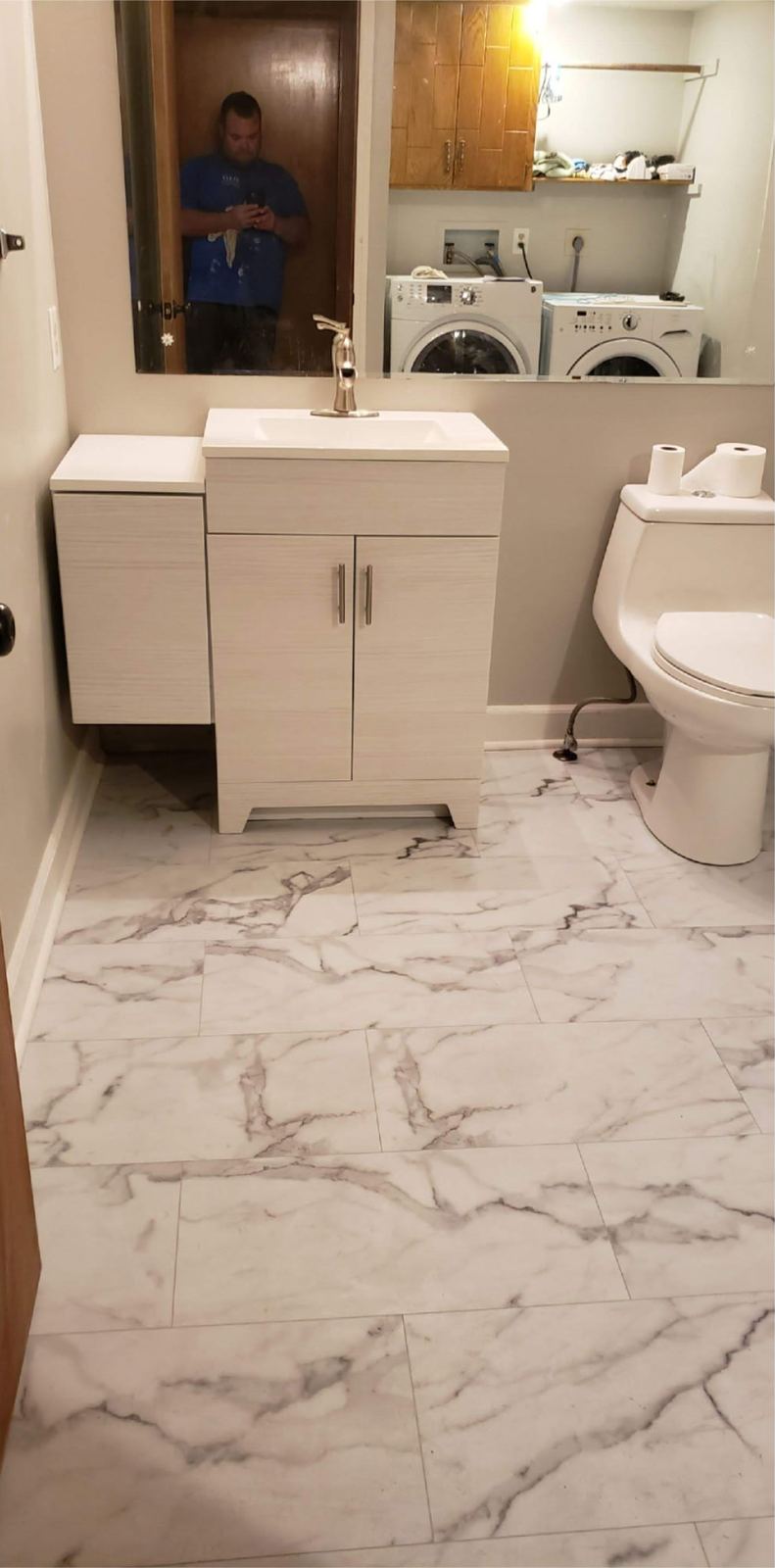 Finished bathroom with marble-look tile floor and a modern vanity