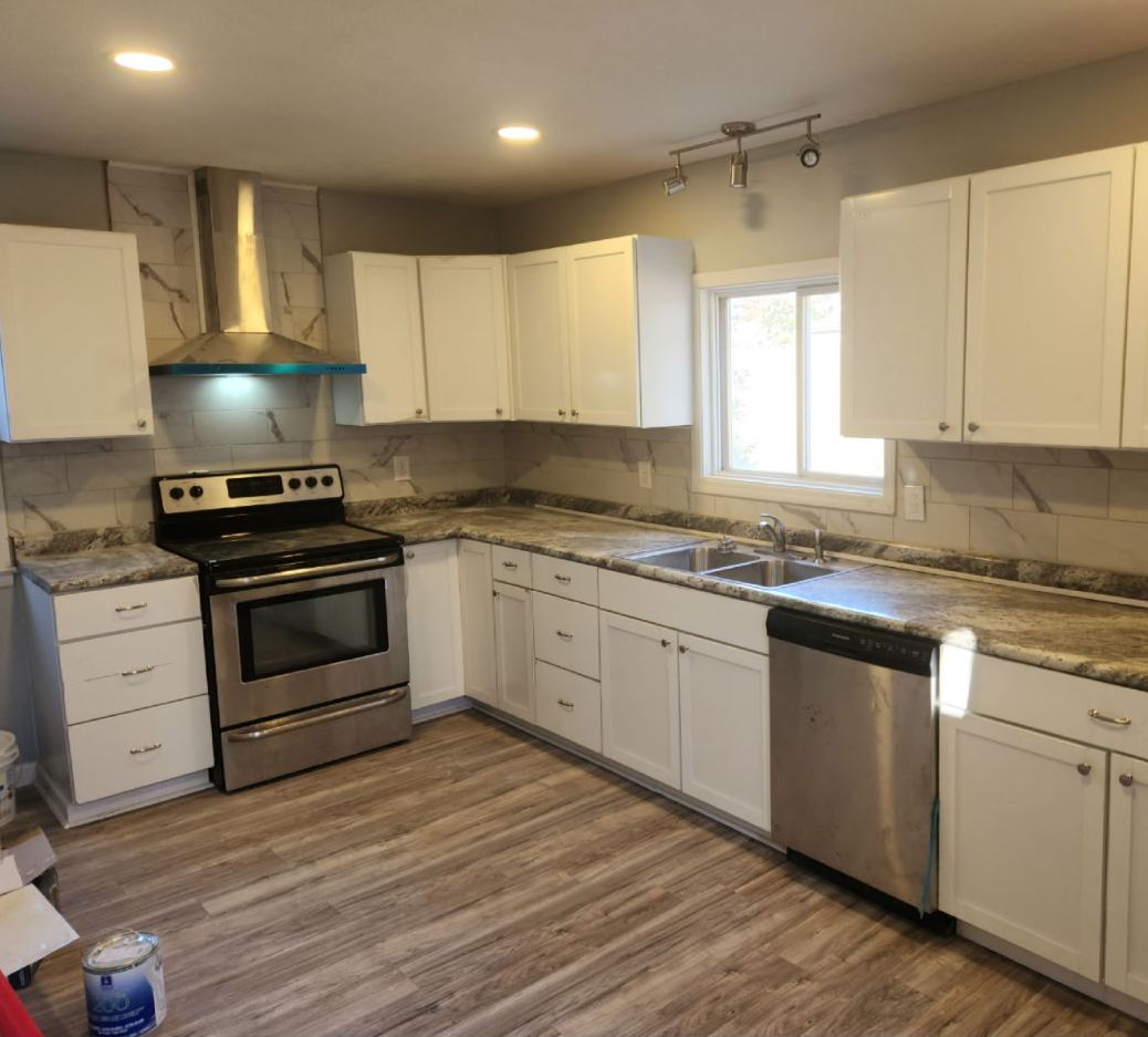 Remodeled kitchen with white shaker cabinets, granite counters and stainless appliances