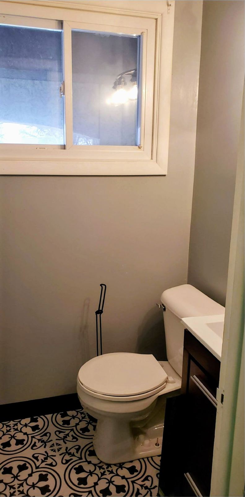Renovated powder room with painted walls and patterned tile flooring