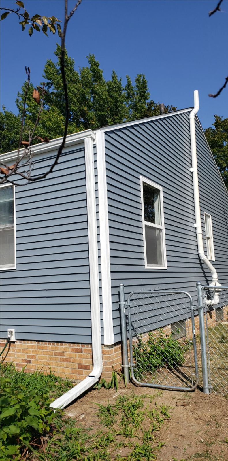 Rebuilt and re-sided exterior wall with new grey siding and gutters